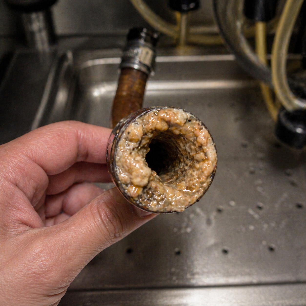 Sticky beverage drip tray with residue buildup and drain line clog concerns